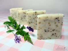 three bars of soap sitting on top of a pink and white checkered table cloth