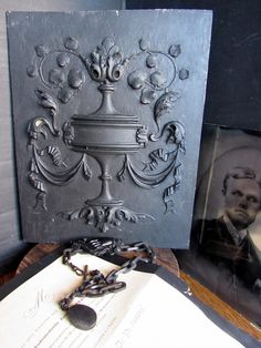 an old photo is on display next to a book with chains hanging from the cover