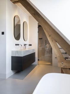 a bathroom with two sinks under a slanted roof