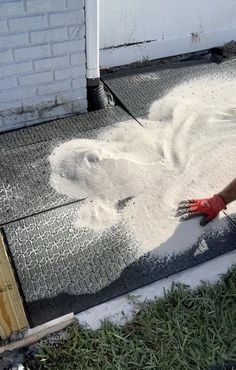 a person in red gloves is sanding up on the ground near a garage door