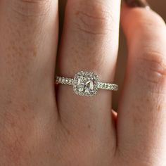 a woman's hand with a diamond ring on top of her finger and an engagement band