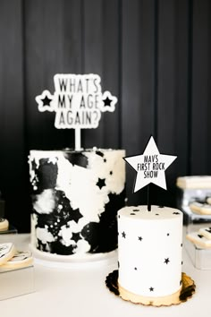 a black and white cake sitting on top of a table next to a sign that says what's my age again?