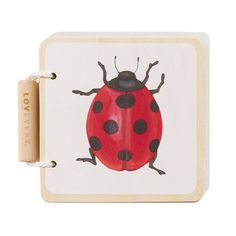 a ladybug painted on the side of a small wooden box with two handles