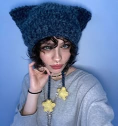 a woman wearing a knitted hat and necklace