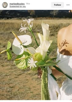 a woman holding a bouquet of white flowers