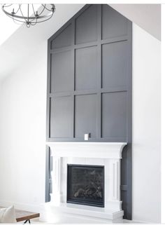 a white fireplace with gray paneling in a living room