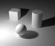 three white objects sitting on top of a gray surface next to each other and one is casting a shadow