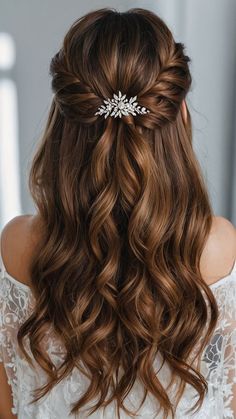 the back of a woman's head with long wavy hair and a flower in her hair