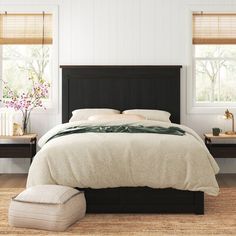 a bedroom with white walls and wooden floors