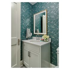 a white sink sitting under a mirror next to a wall mounted faucet in a bathroom