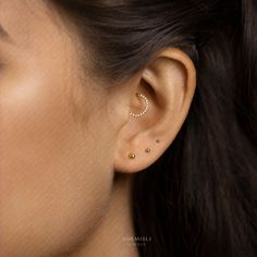 a woman's ear is shown with two small pearls