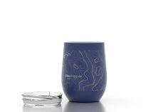 a blue wine glass sitting next to a silver bowl on a white surface with the words downpour written across it