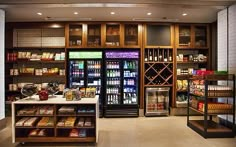 the inside of a grocery store with shelves full of food and drinks on display behind glass doors