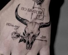 a person's hand with a tattoo on it that has a long horn and flowers