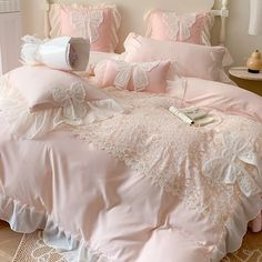 a bed with pink comforters and pillows on it