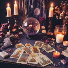 a table topped with cards and candles next to a glass ball filled with flowers on top of it