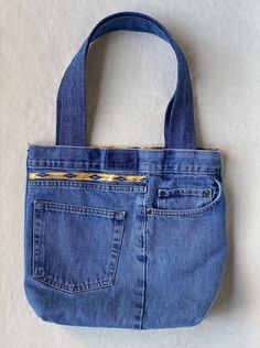 a blue jean purse sitting on top of a white surface