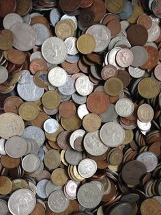 a pile of different types of coins sitting on top of each other