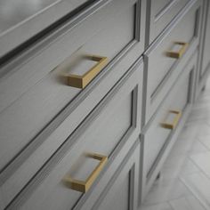 a close up of a dresser with brass handles