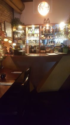 an empty bar is lit up at night with christmas lights on the shelves and decorations