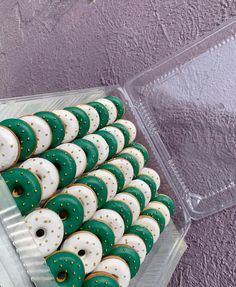 green and white decorated cookies in a plastic container