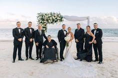 a group of people standing next to each other on a beach