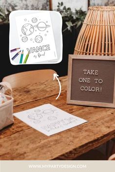 a wooden table topped with a sign next to a wicker basket filled with eggs