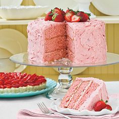 there is a strawberry cake on the table with two slices taken out of it and strawberries on the plate