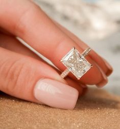 a woman's hand with a ring on her finger and a diamond in the middle