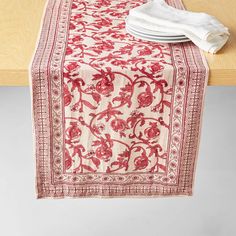 a red and white table runner on top of a wooden table