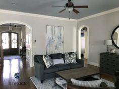 a living room filled with furniture and a large mirror on the wall above it's doorway