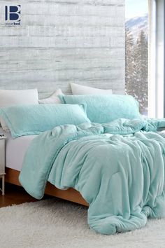 a bed with blue comforters and pillows on top of it