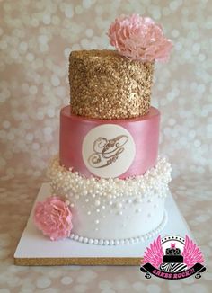 a three tiered cake with pink flowers on top and gold sequins around the edges