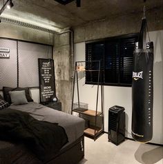 a bed room with a neatly made bed and boxing punching bag on the wall next to it