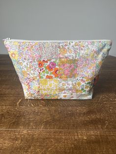 a flowered bag sitting on top of a wooden table