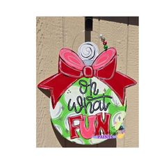 an ornament hanging on the side of a building that says, oh what fun?