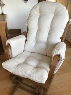 a white recliner chair sitting in a living room next to a clock on the wall