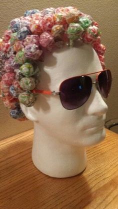 a white mannequin head wearing sunglasses and a crocheted flowered hat