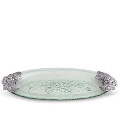 a green glass dish with silver flowers on the rim and two leaves in the middle