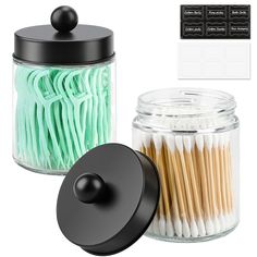 a glass jar with matchesticks in it next to a black lid and stickers