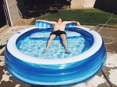 a man floating in an inflatable pool on top of a swimming ring,