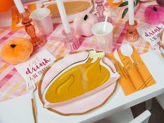 the table is set with pink and orange decorations