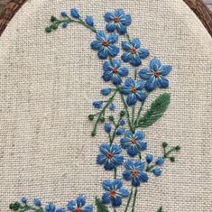 a close up of a cross stitch pattern with blue flowers