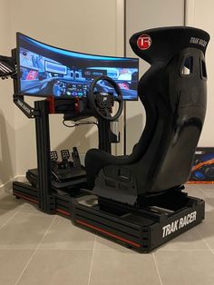 a video game driving simulator sitting on top of a black stand in front of a white wall