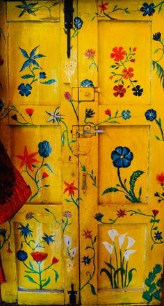 a yellow door with flowers painted on it