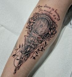 a tattoo on the leg of a person with a clock and flowers around it,