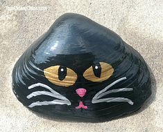 a painted rock with a cat's face on the rocks is shown in this image