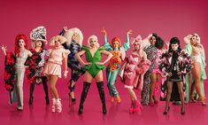 a group of barbie dolls standing next to each other on a pink background in front of the camera