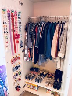 a closet filled with lots of baby shoes and clothes hanging on the wall next to it