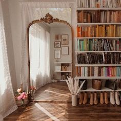 a bookshelf filled with lots of books next to a window